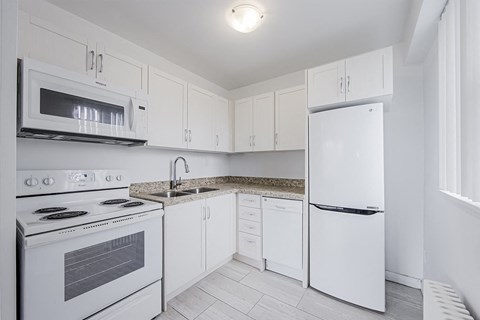a white kitchen with white appliances and white cabinets at 161 St. George, Toronto California  